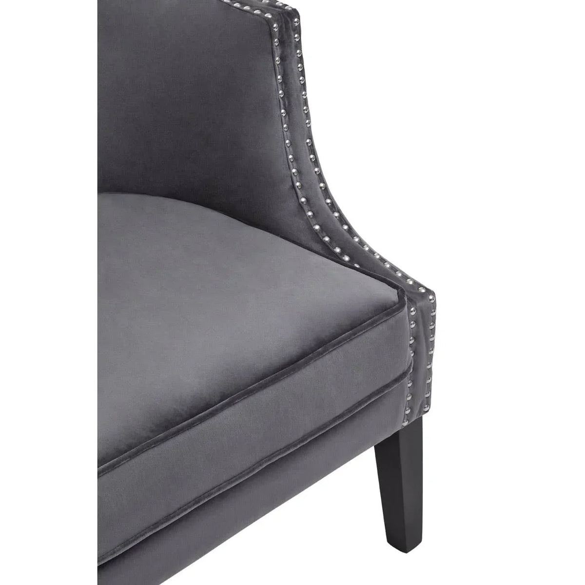 Grey velvet accent chair with silver stud detailing and black wooden leg close-up
