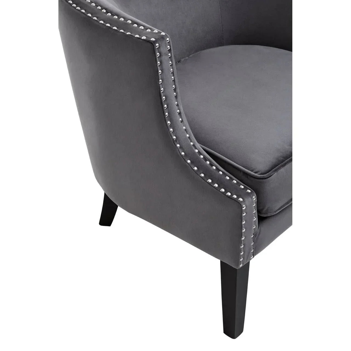Closeup of grey velvet accent chair with silver studded trim and dark wooden legs