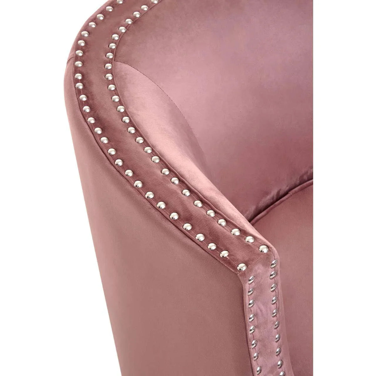 Close up of pink velvet armchair with silver stud detailing along the edge