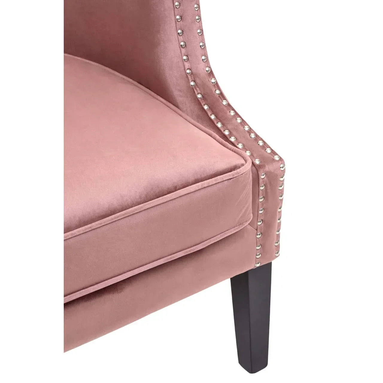 Blush pink velvet accent chair with silver stud trim and dark wooden leg