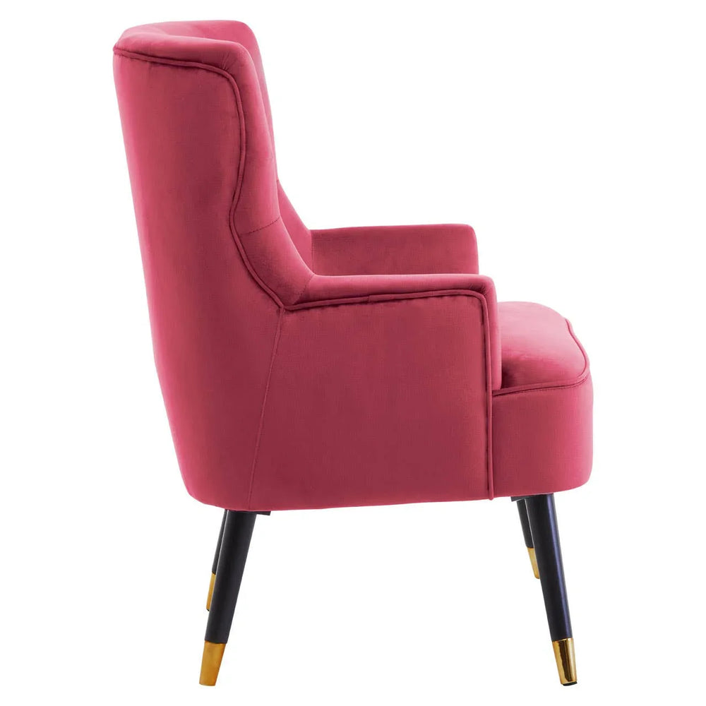 Side view of pink velvet armchair with gold-tipped black legs