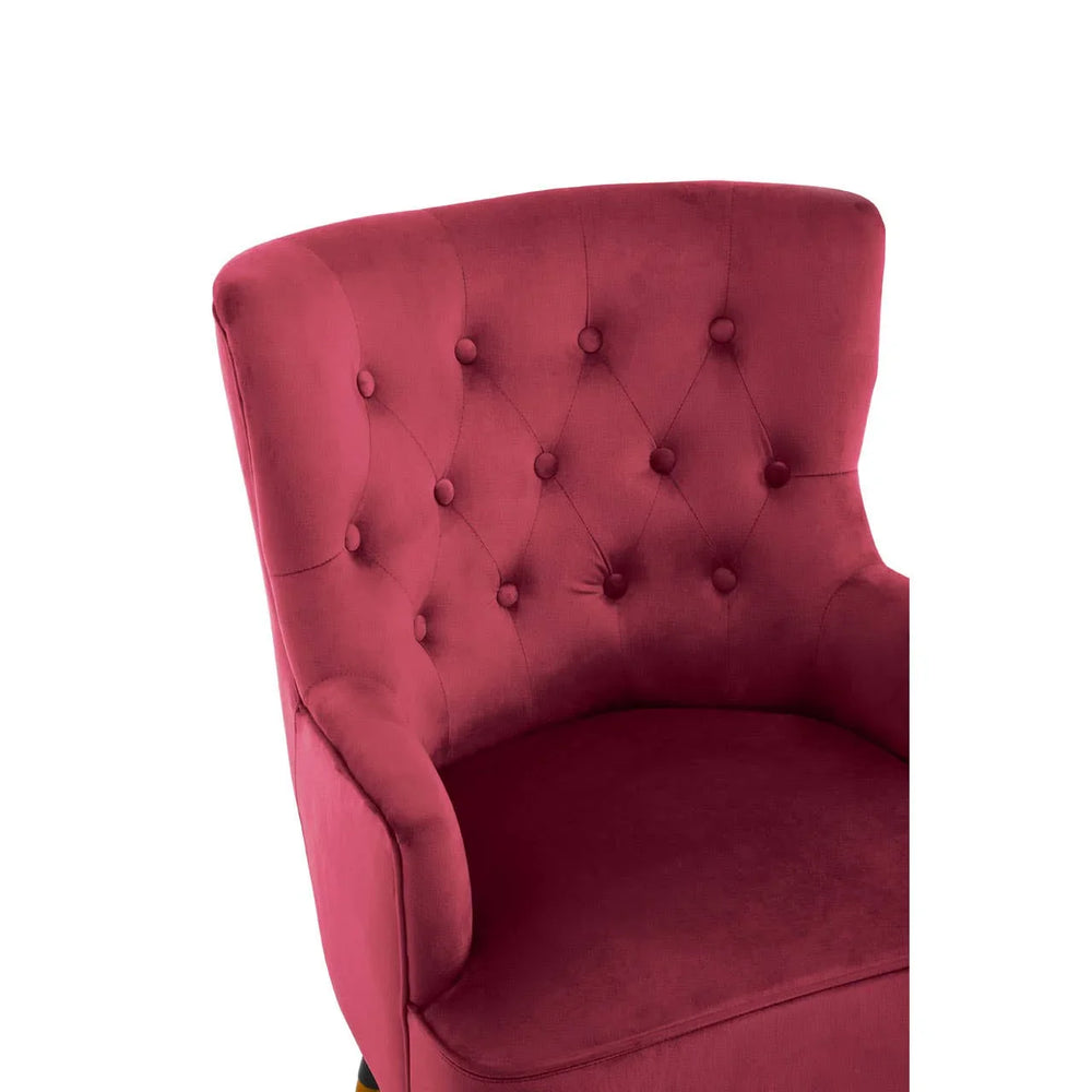 Red velvet accent chair with button tufted backrest, close view of seat and arm detail