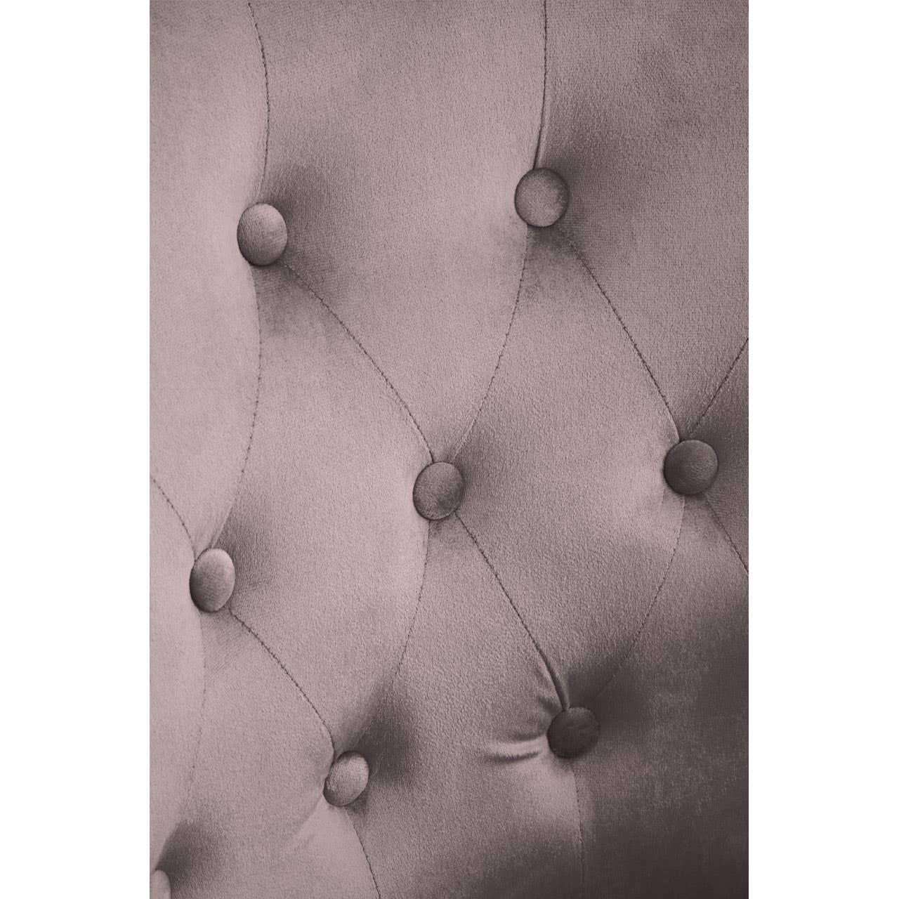 Closeup of velvet sofa upholstery with button tufted diamond pattern in mauve