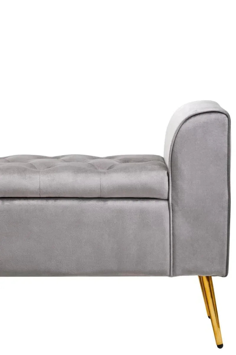 Grey velvet storage bench with gold metal legs and button tufted seat, side view