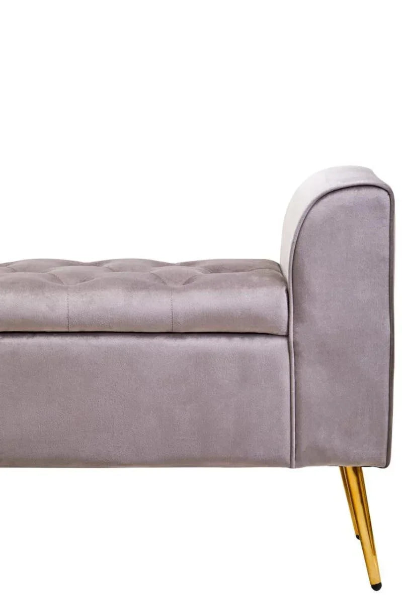 Grey velvet upholstered bench with button-tufted seat and gold metal legs, side view