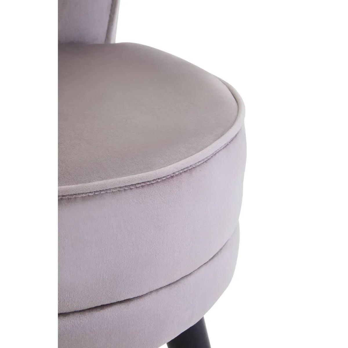 Close-up of light grey velvet dining chair seat with soft upholstery and black wooden leg