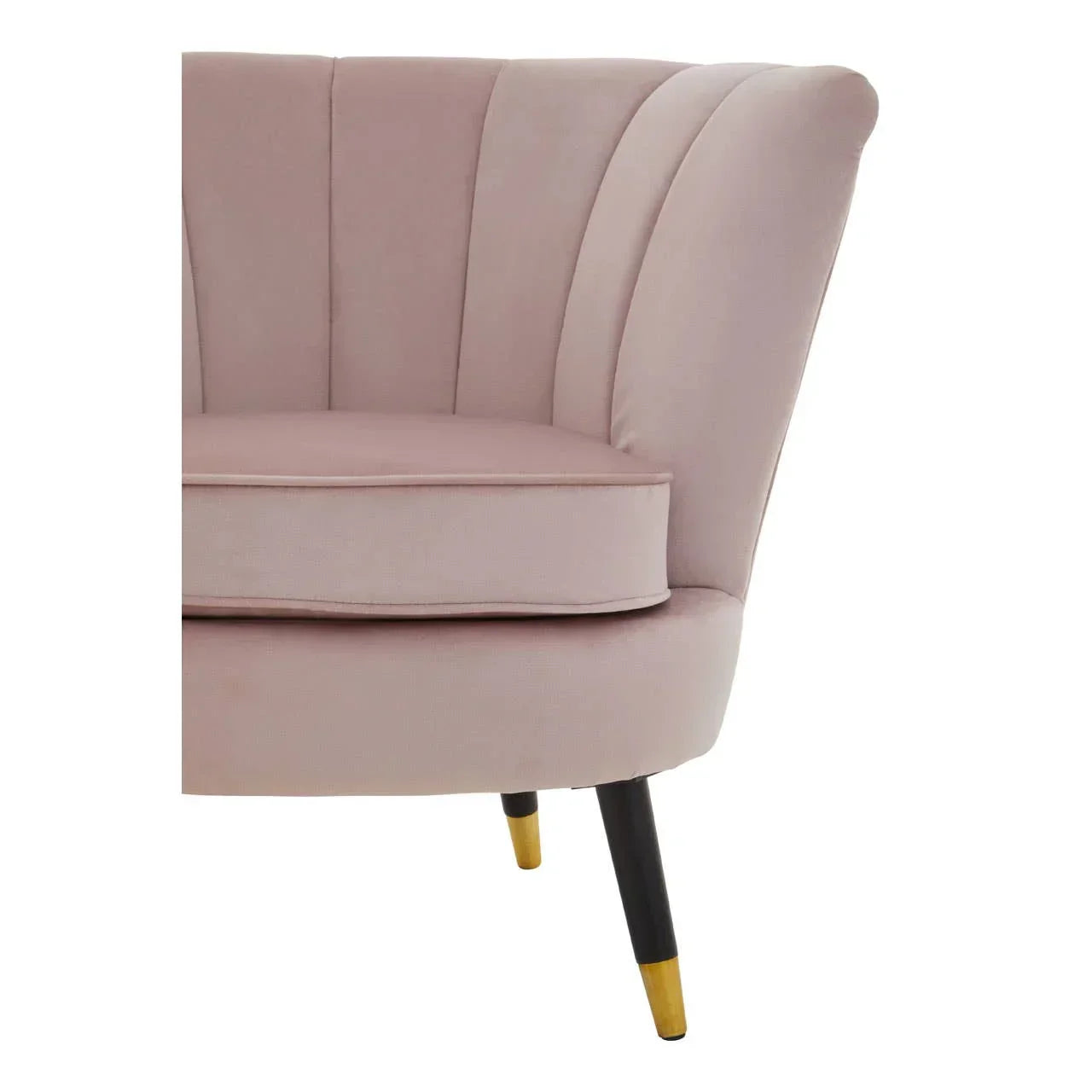 Blush pink velvet armchair with scalloped back and gold-tipped black legs, close-up view