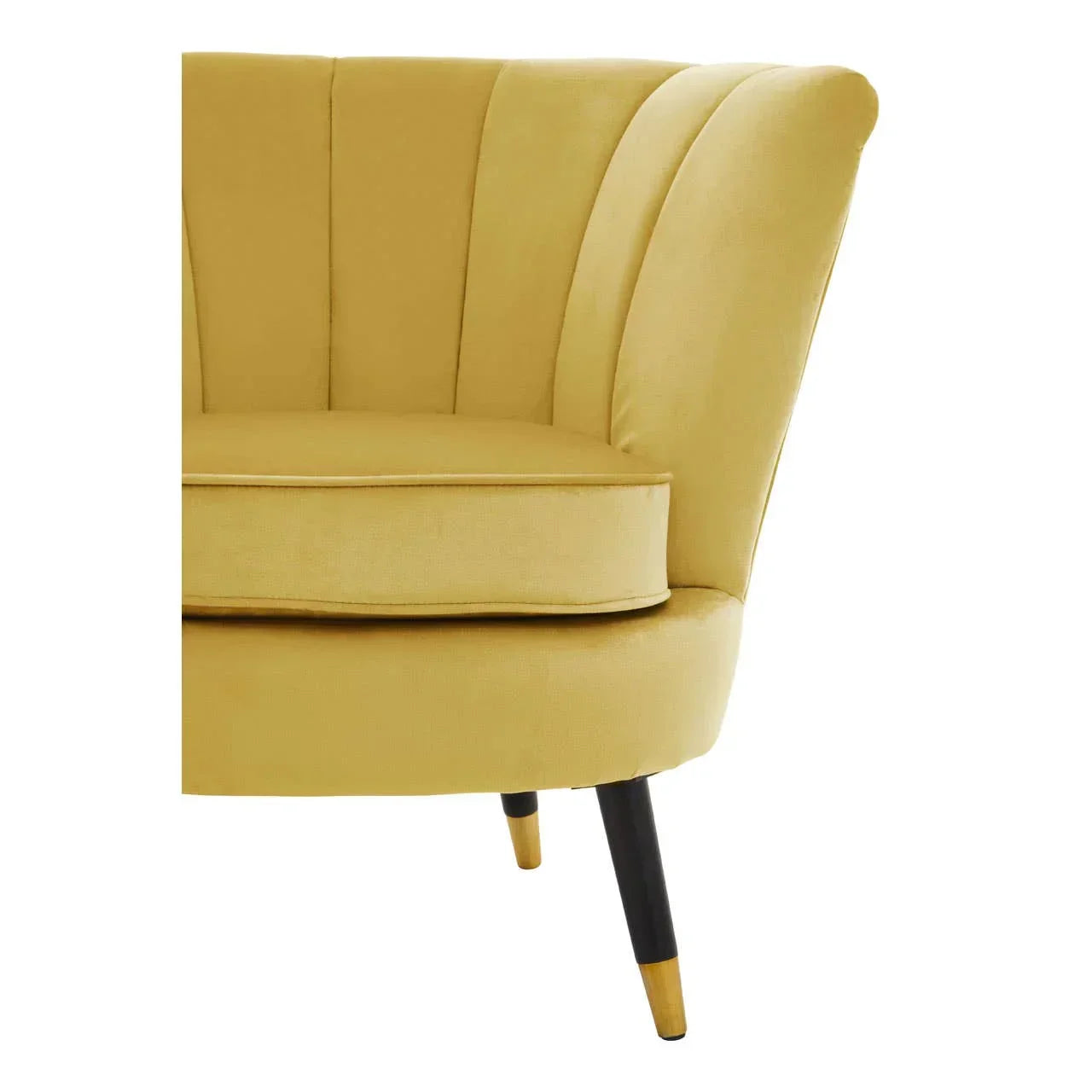 Mustard yellow velvet sofa with flared backrest and black tapered legs, close-up view
