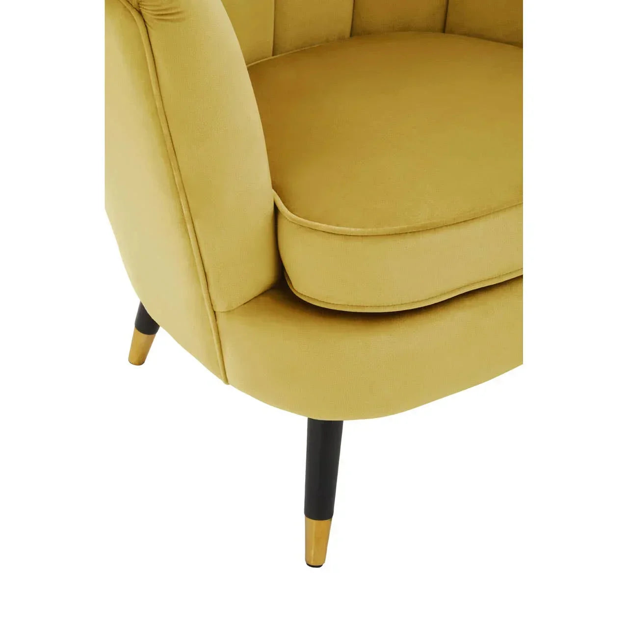 Closeup of yellow upholstered armchair with tapered black and gold legs