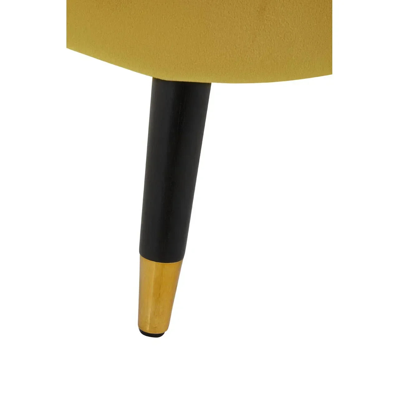 Close-up of black and gold tapered furniture leg attached to mustard yellow upholstered chair