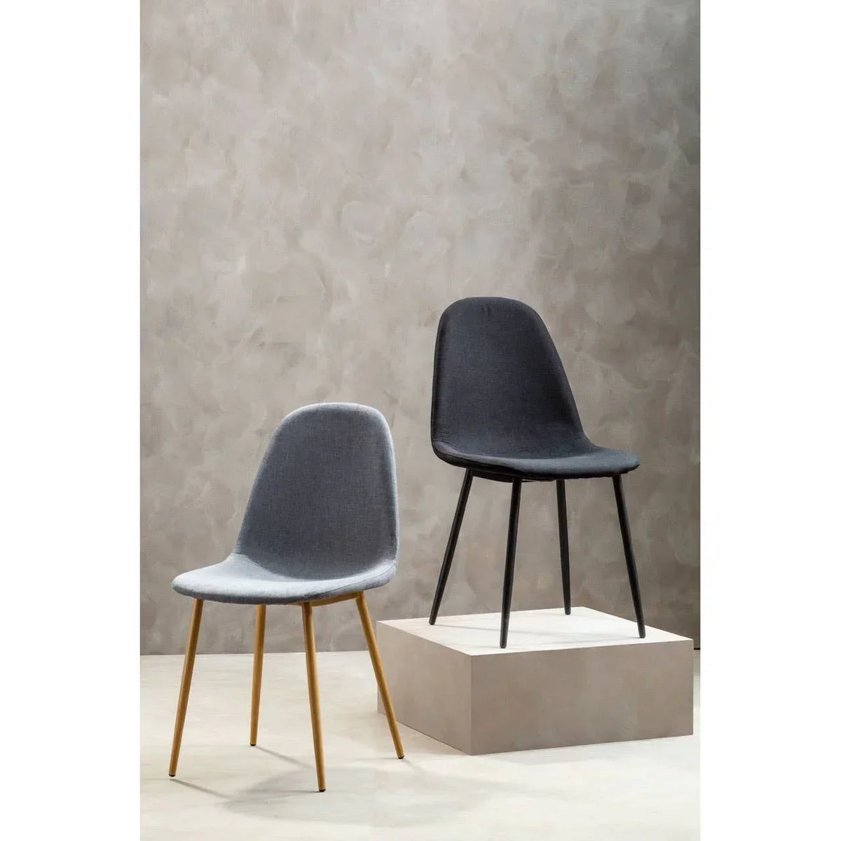 Set of two modern dining chairs, one grey with wooden legs, one dark grey with black legs