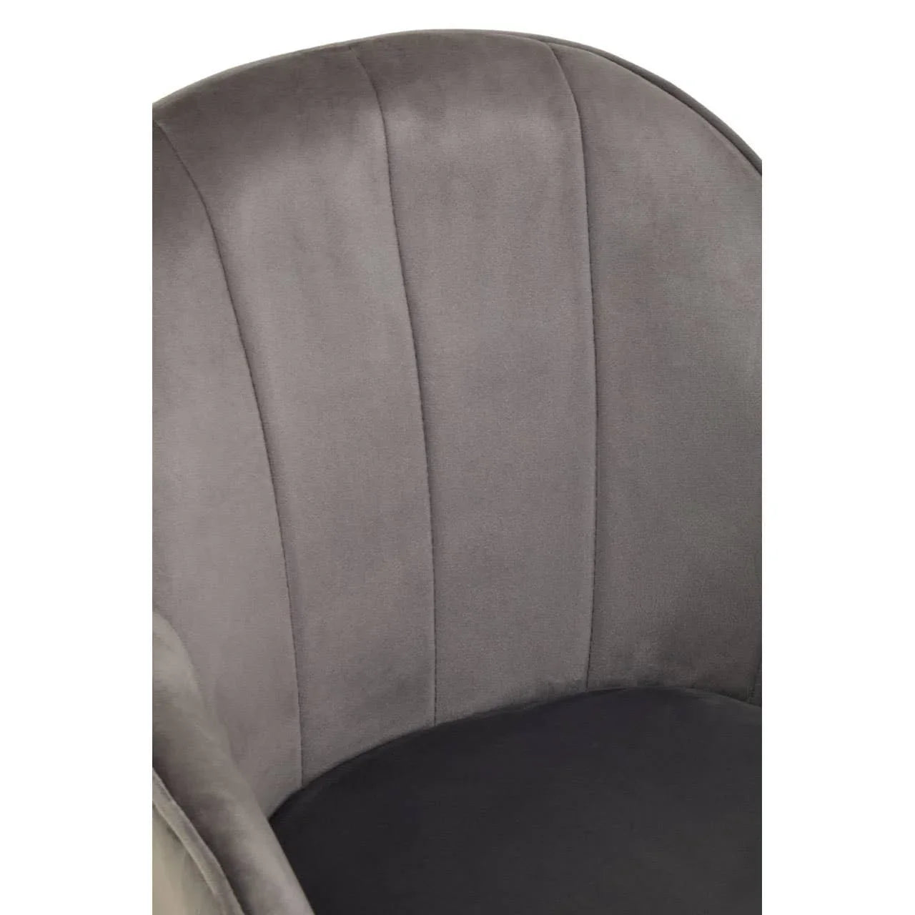 Close-up of grey velvet accent chair with curved backrest and stitched panel detailing