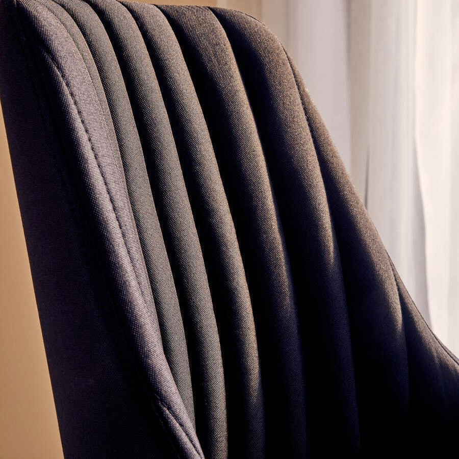 Close view of dark fabric dining chair with vertical stitched detail on backrest