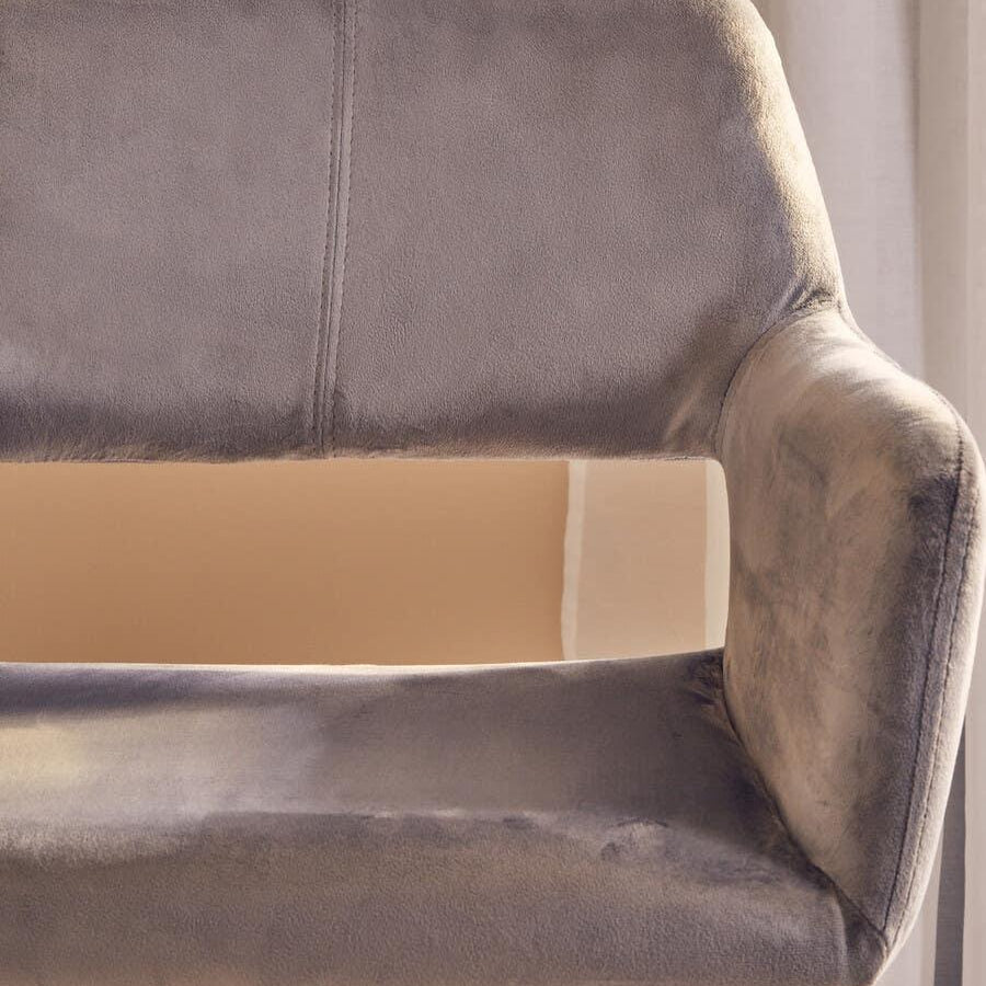 Grey velvet bar stool with chrome base and adjustable lever, close-up of backrest