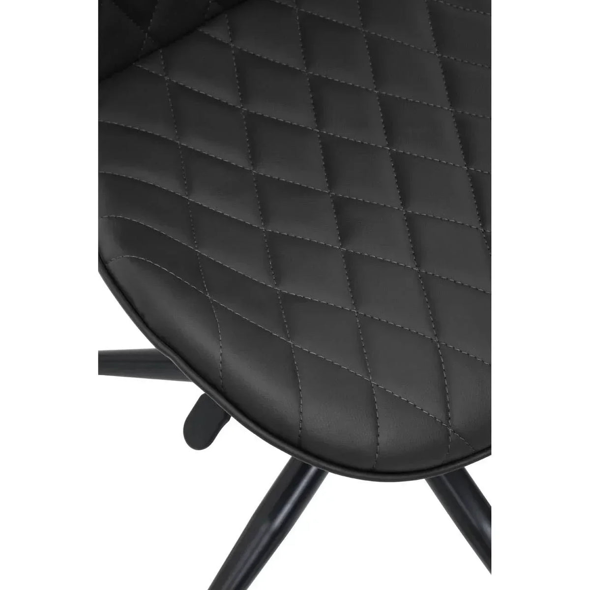 Closeup of black faux leather dining chair seat with diamond stitch pattern and metal legs