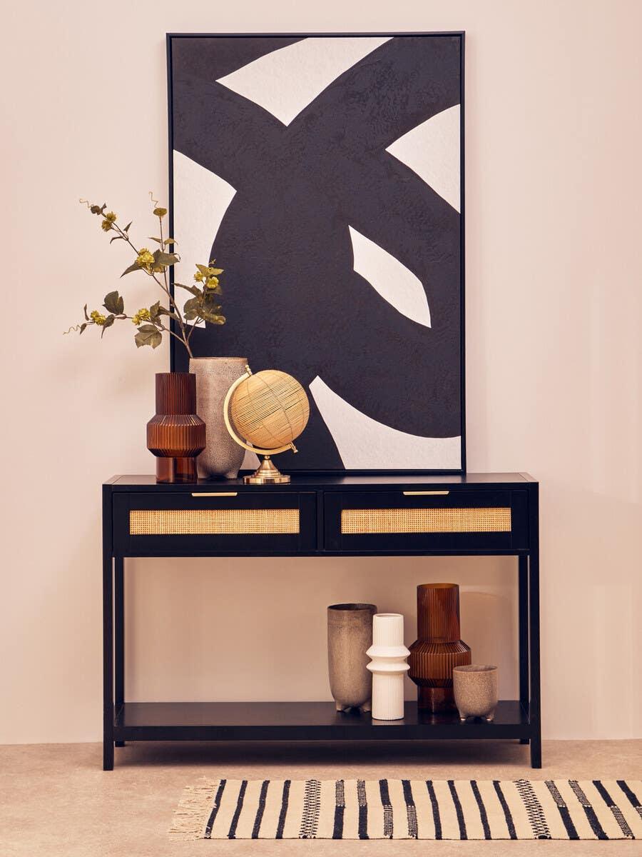 Black console table with rattan drawers, decorative vases and globe, modern abstract wall art