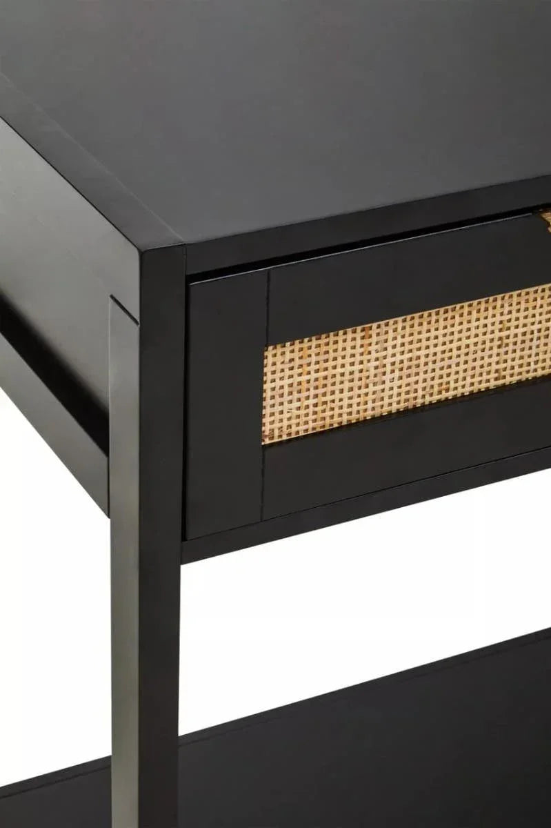 Black wooden bedside table with rattan drawer front, close-up corner view
