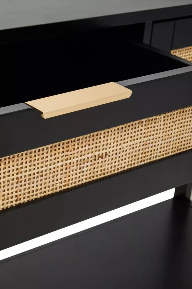 Black wooden drawer with rattan front panel and gold handle, close-up view