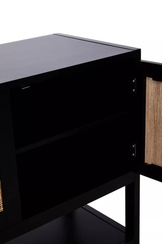 Black wood side cabinet featuring two doors with rattan inserts, showcasing a sleek design and a spacious interior with two shelves. The cabinet has a smooth top surface and a minimalist aesthetic, suitable for various home decor styles