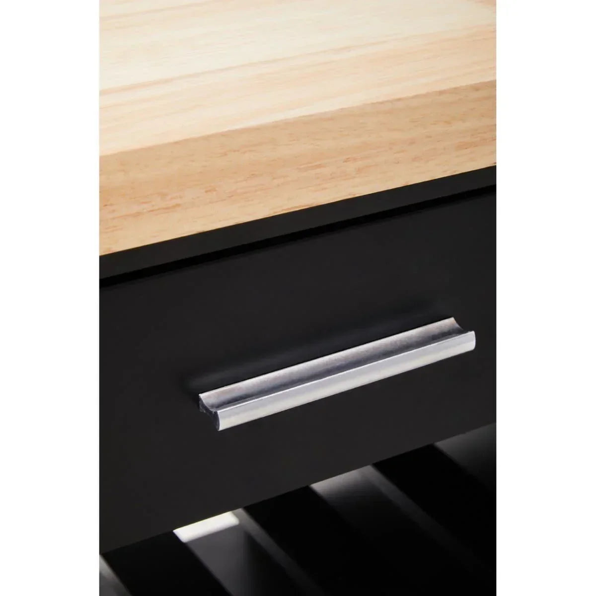 Closeup of wooden table top with black drawer and silver handle