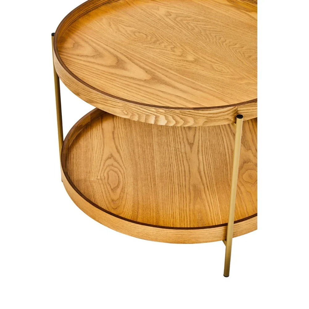 Round oak wood coffee table with lower shelf and gold metal legs, angled close-up view