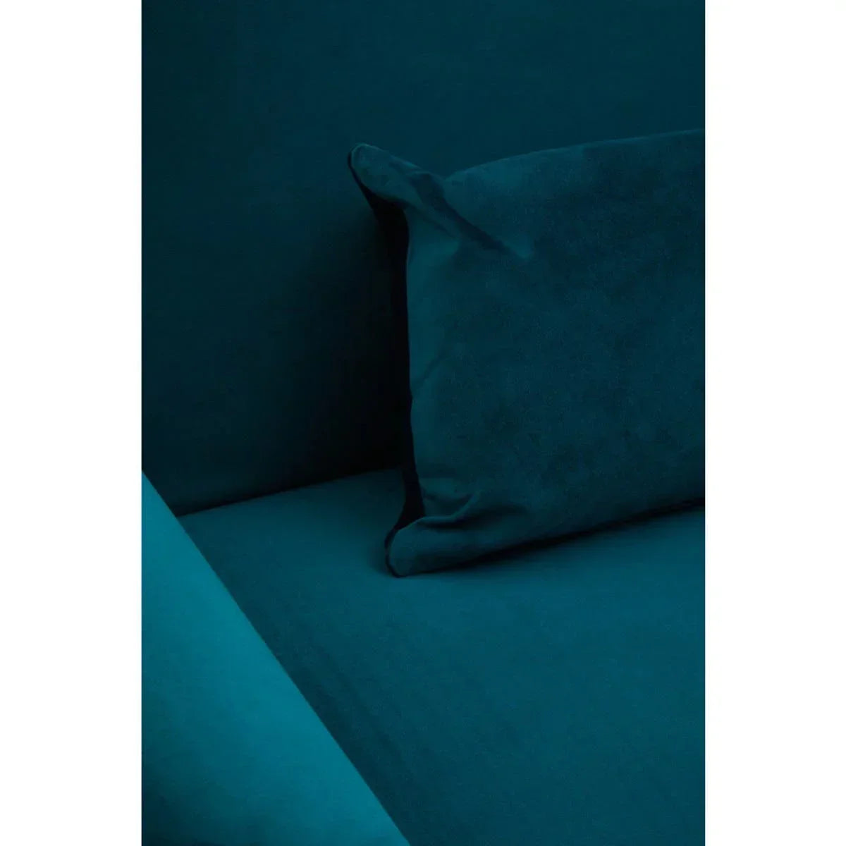 Teal velvet sofa with matching cushion close-up