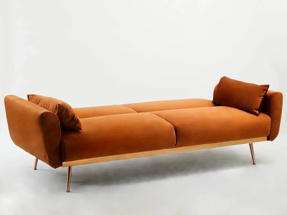 Modern orange velvet sofa bed with slim metal legs and matching cushions on white background