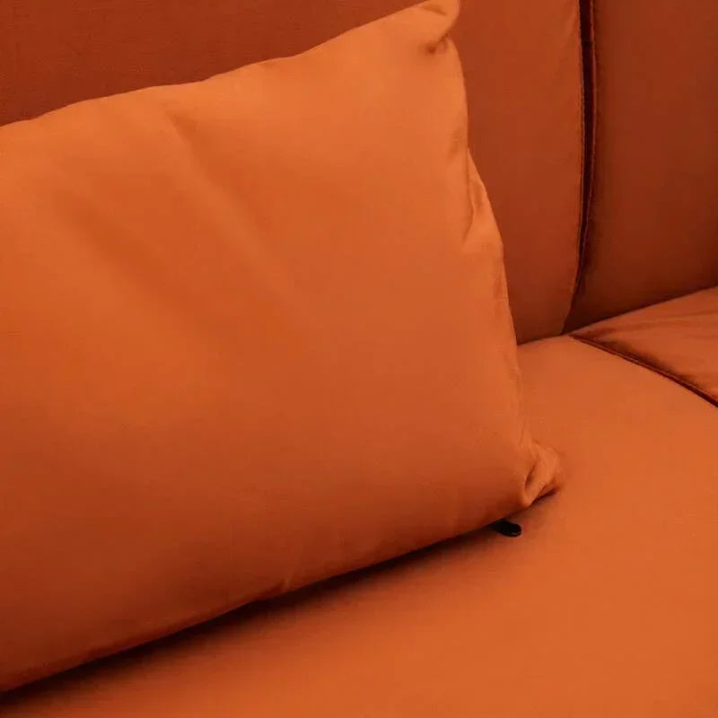 Close-up of orange sofa cushion on matching upholstered seat