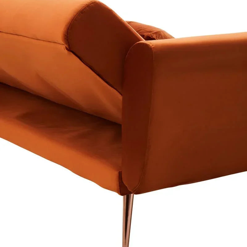Close-up of orange velvet sofa with metal leg