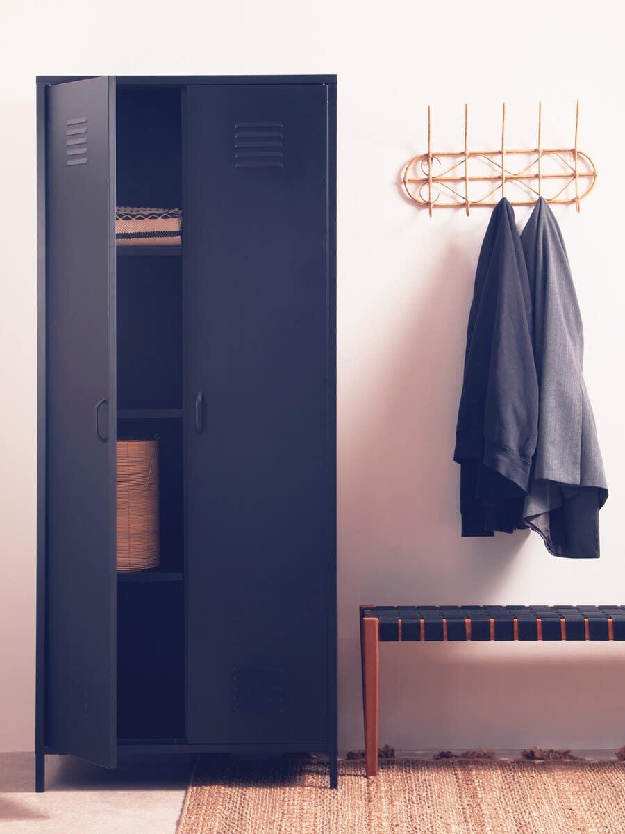 Black metal storage cabinet with open doors beside bench and wall coat rack in entryway