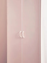 Pink wardrobe with double doors and white handles against a light wall