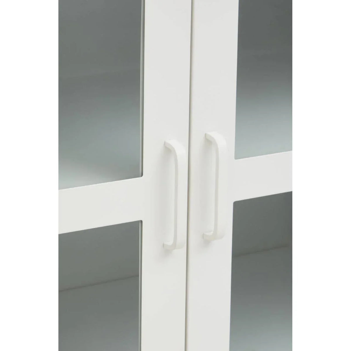 White cabinet doors with glass panels and modern handles close up