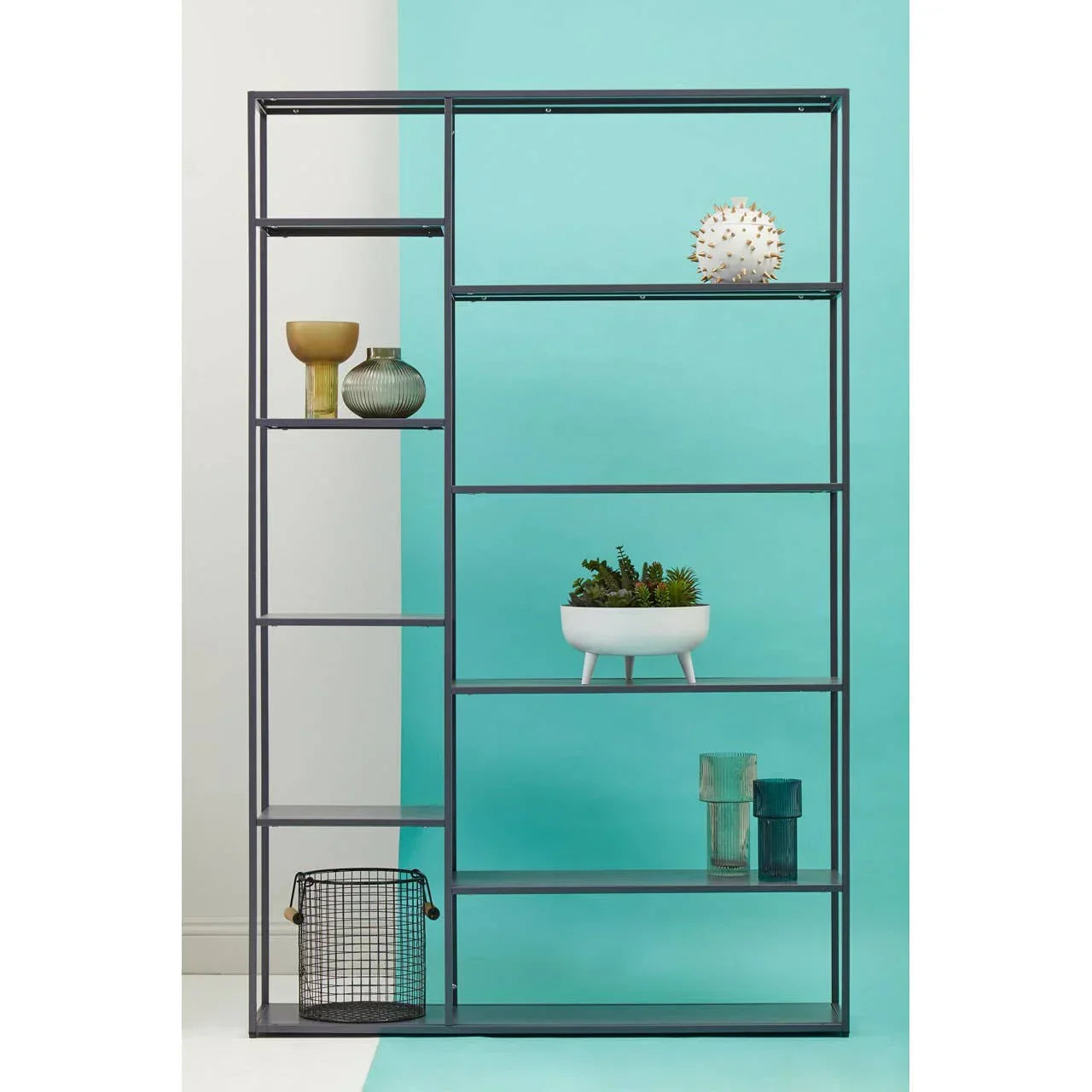Black metal shelving unit with modern decor and plants on turquoise background