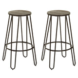 A three-piece bar table and stool set featuring a round wooden tabletop with a distressed finish and two matching metal stools with slender legs and circular seats, designed for a modern and stylish look