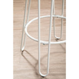 White metal frame of a bar stool featuring slender legs and a circular footrest, set against a light wooden floor