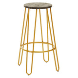 Gold finish metal frame bar stool with a round wooden seat and slender, angled legs. The stool features a minimalist design, showcasing a combination of metal and wood materials