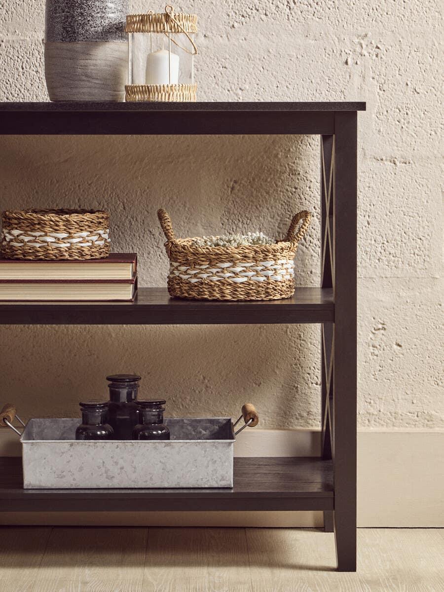Dark wood console table with woven baskets and candle holder for home storage