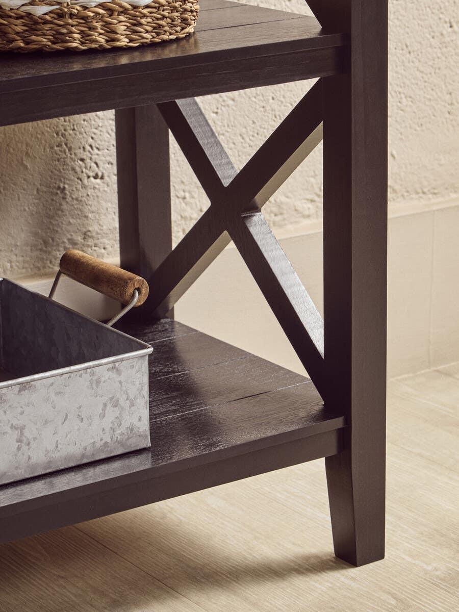 Black wooden console table with cross-leg design and lower shelf in modern interior