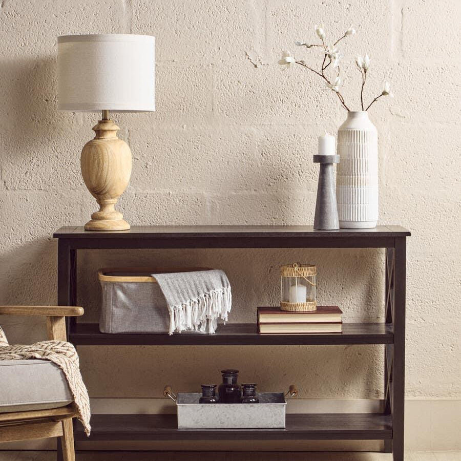 Dark wood console table with lamp, ceramic vase, storage basket and decorative tray