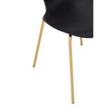 Black dining chair with gold metal legs close-up