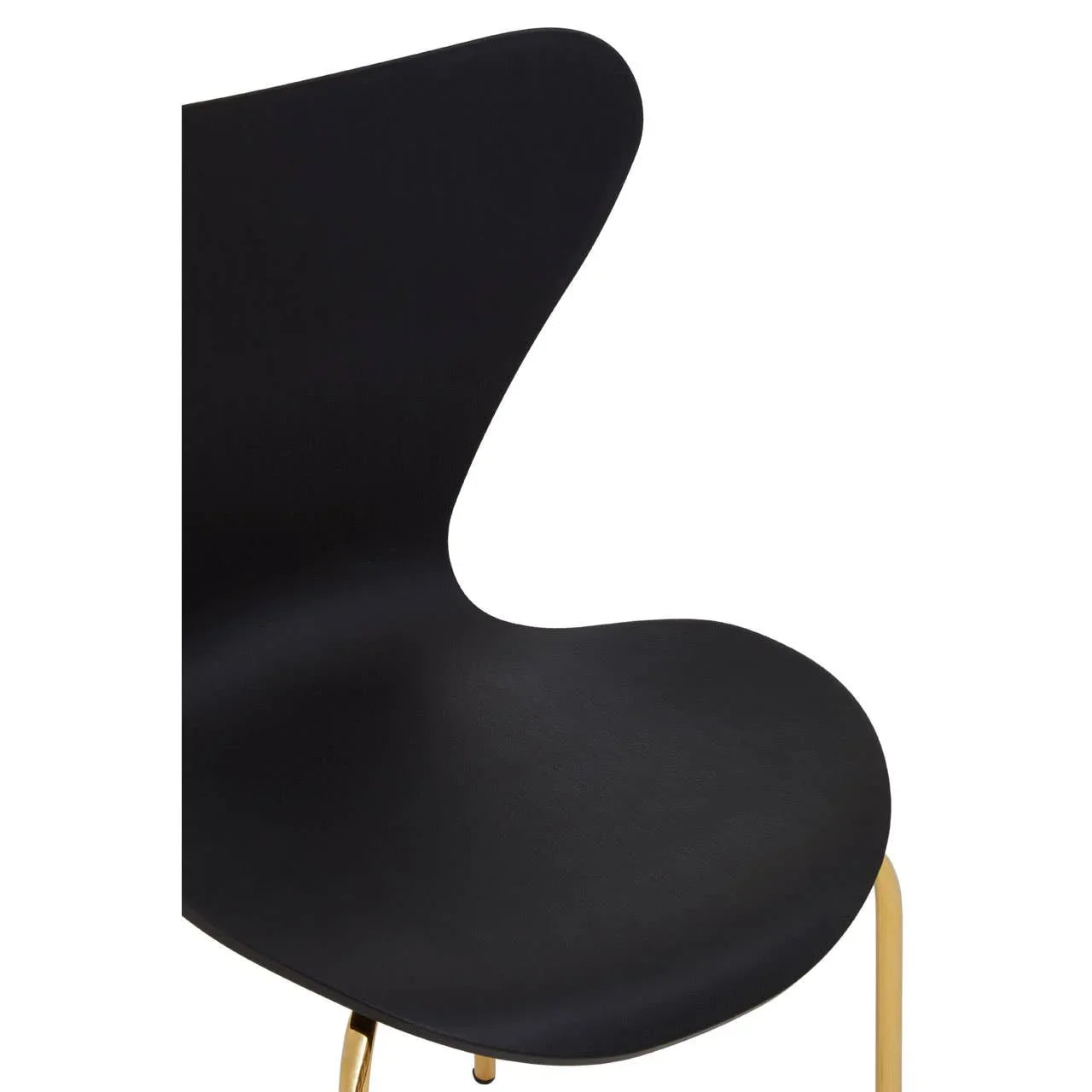 Black dining chair with curved seat and gold metal legs, close side view
