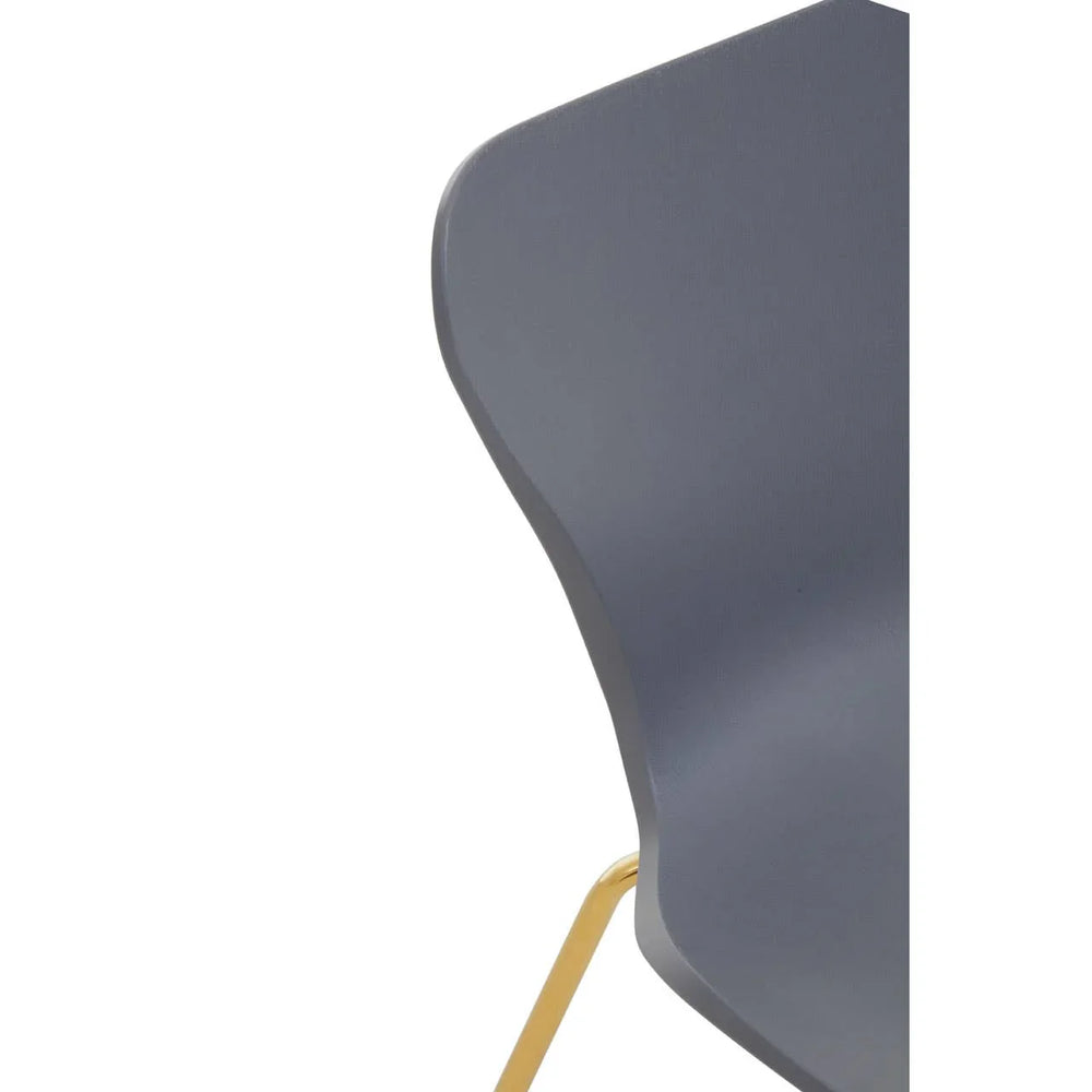 Grey dining chair with gold metal leg and curved backrest close-up