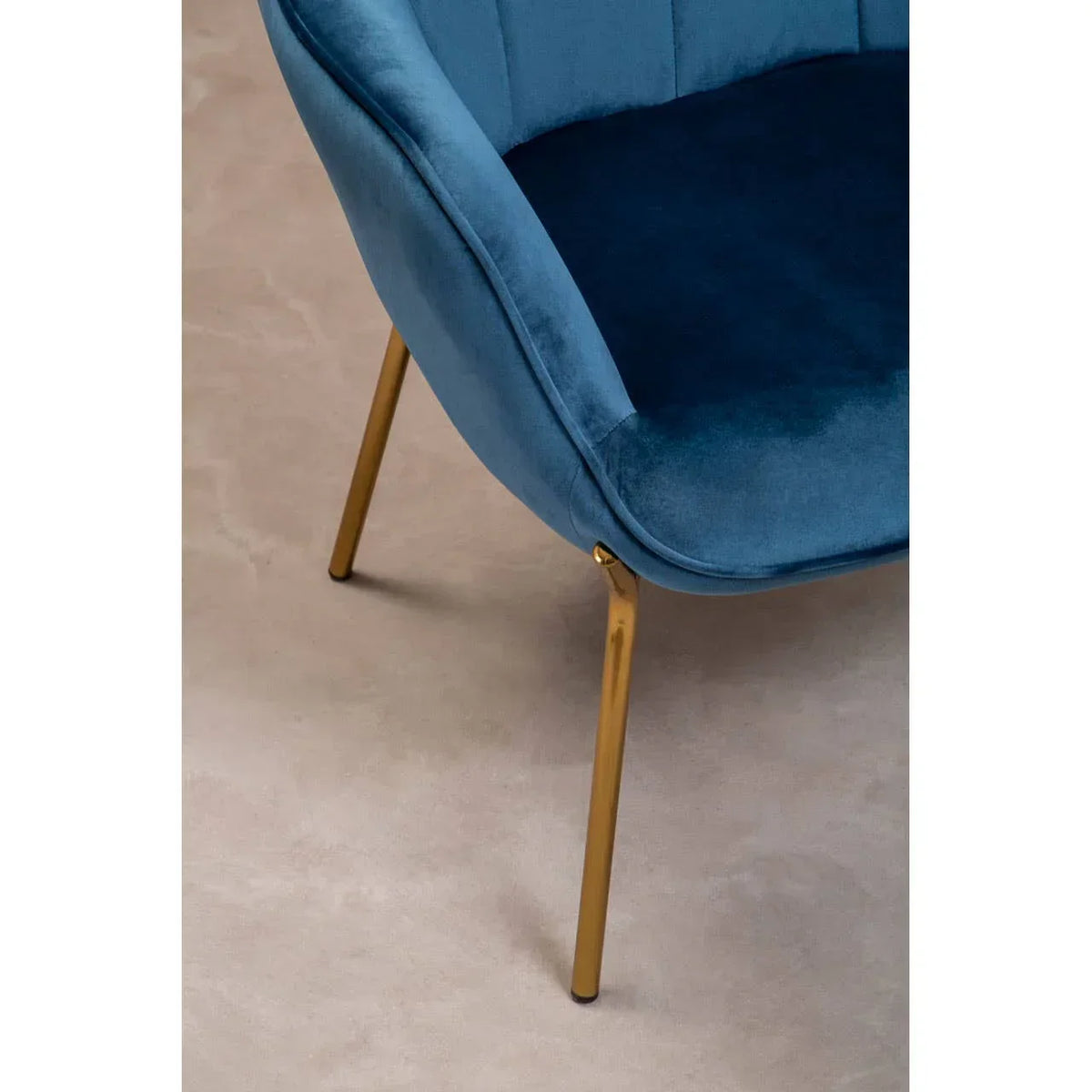 Blue velvet accent chair with gold metal legs, close-up of seat and frame