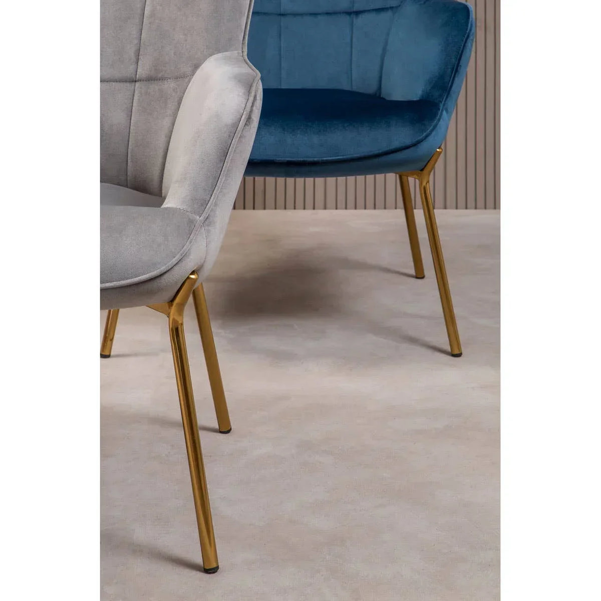 Velvet accent chairs with gold legs in blue and grey on light carpeted floor