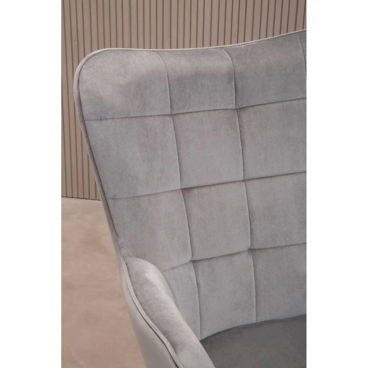 Grey fabric armchair with quilted backrest, close-up of upholstery and stitching detail