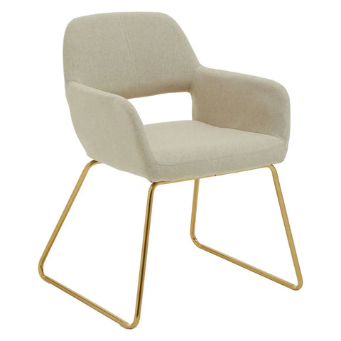 Beige fabric dining chair with gold metal legs and open-back armrests on white background