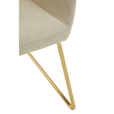 Beige fabric chair seat with gold metal leg, close-up on upholstery and frame detail