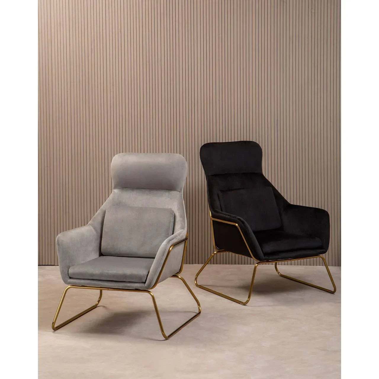 Grey and black accent chairs with gold metal frames on neutral background