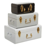 Set of three metal storage trunks in black, grey, and white with gold latches and handles