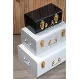 Set of three metal storage trunks in black and white with gold clasps and handles